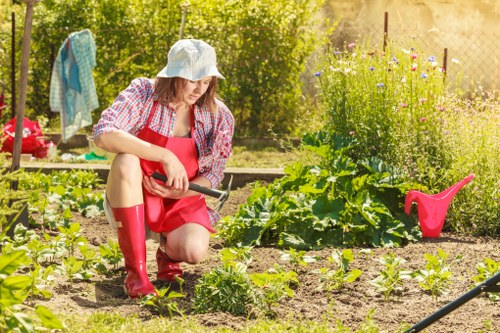 Front view of a trimmed lawn in Spitalfields with a gardener preparing equipment